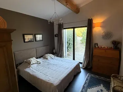 a bedroom with a bed and a large window at Le mas Donalia in Saint-Saturnin-les-Apt