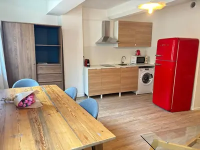 a kitchen with a wooden table and a red refrigerator at Chez Fleur in Aix-en-Provence