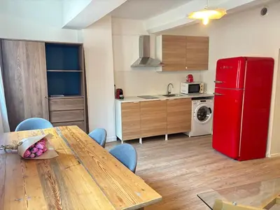 a kitchen with a table and a red refrigerator at Chez Fleur in Aix-en-Provence