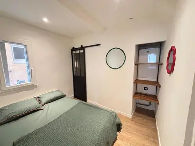 a bedroom with a green bed and a mirror at Chez Fleur in Aix-en-Provence