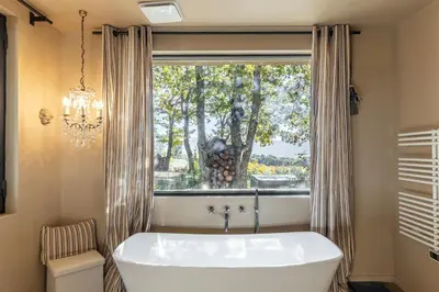 a bath tub in a bathroom with a window at Madame Luberon in Roussillon