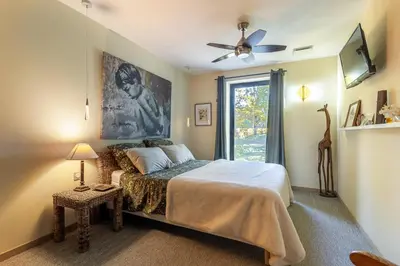 a bedroom with a bed with a ceiling fan and a window at Madame Luberon in Roussillon