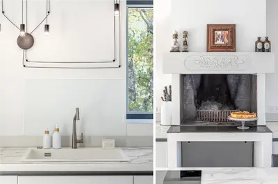 a white kitchen with a fireplace and a sink at Madame Luberon in Roussillon