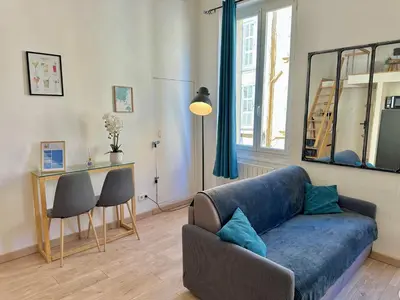 a living room with a blue couch and a window at Le Bleu Salonais - Centre ville in Salon-de-Provence