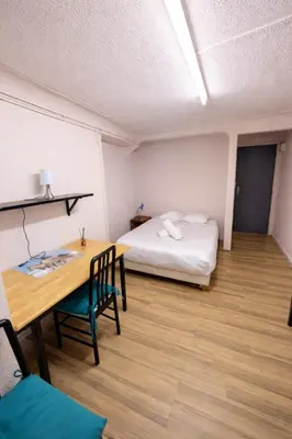 a bedroom with a bed with a white and red comforter at Chambre Centre Aix Salle de Bain privée in Aix-en-Provence