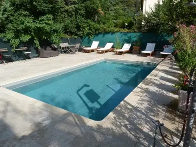 a swimming pool with some chairs and a table at Le Clos d'AIX studio 211 in Aix-en-Provence