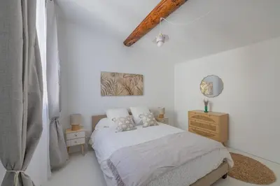 a white bedroom with a bed with two pillows at Appartement Belle Lettre 8 in Aix-en-Provence