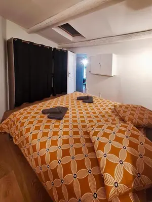 a large orange bed in a room with at L'olivade in La Fare-les-Oliviers