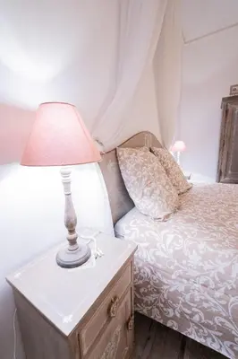 a lamp on a dresser next to a bed at La Maison de Claire à Plan d'Orgon in Plan-dʼOrgon