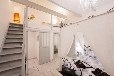a room with a bed and a staircase at La Maison de Claire à Plan d'Orgon in Plan-dʼOrgon