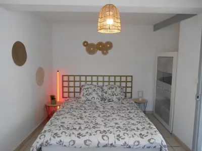 a bedroom with a bed and a chandelier at Maison lumineuse proche du centre in Carpentras
