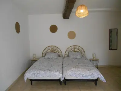 a bedroom with a bed and a chandelier at Maison lumineuse proche du centre in Carpentras