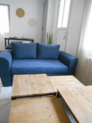 a blue couch in a living room with a table at Maison lumineuse proche du centre in Carpentras