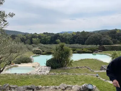 a person standing in front of two swimming pools at Mas, Padel privé, tennis privé, piscine 22m , Alpilles Provence in Orgon
