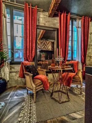 a living room with a table and red curtains at Esmeralda centre historique in Aix-en-Provence