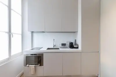 a kitchen with white cabinets and a sink at Le Zola - Studio premium hypercentre - Wifi - Climatisation in Aix-en-Provence