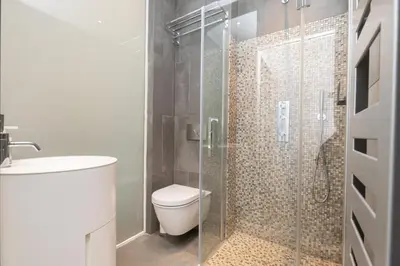 a bathroom with a toilet and a glass shower at Le Zola - Studio premium hypercentre - Wifi - Climatisation in Aix-en-Provence