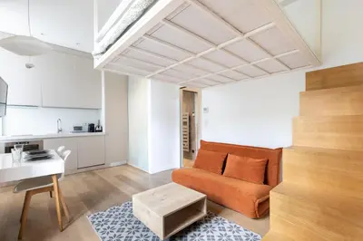 a living room with an orange couch and a table at Le Zola - Studio premium hypercentre - Wifi - Climatisation in Aix-en-Provence