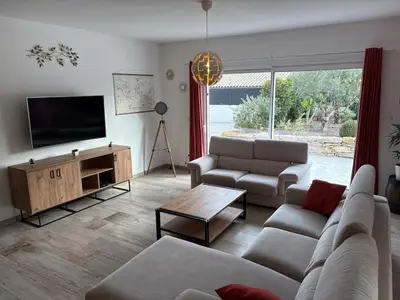 a living room with a couch and a flat screen tv at Grande maison familiale tout confort in Éguilles