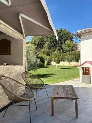 a patio with two chairs and a wooden table at Grande maison familiale tout confort in Éguilles