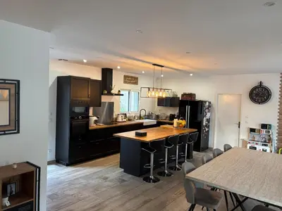 a kitchen with black appliances and a table with chairs at Grande maison familiale tout confort in Éguilles