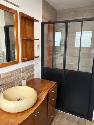 a bathroom with a wooden sink and a glass shower at Grande maison familiale tout confort in Éguilles