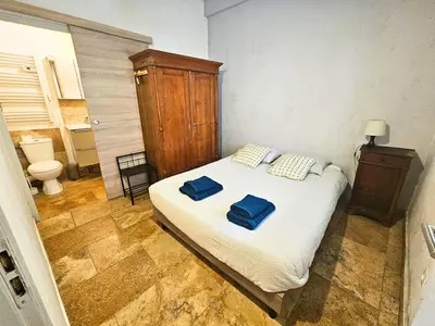 a bedroom with a bed with two blue towels on it at Au coeur de la Venise Povençale in LʼIsle-sur-la-Sorgue
