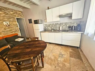 a kitchen and dining room with a wooden table at Au coeur de la Venise Povençale in LʼIsle-sur-la-Sorgue