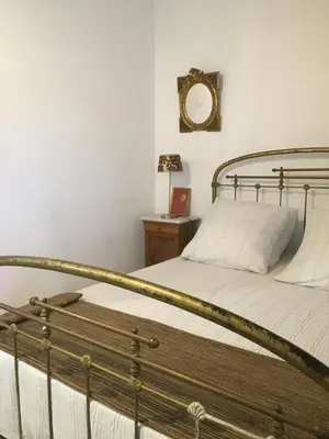 a bedroom with a bed with a metal frame at Superbe appartement dans la Venise Provençale in LʼIsle-sur-la-Sorgue