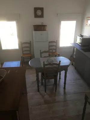 a kitchen with a table and chairs in a room at Superbe appartement dans la Venise Provençale in LʼIsle-sur-la-Sorgue