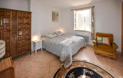 a bedroom with a bed and a chair and a window at Pet Friendly Home In Gargas With Wifi in Gargas
