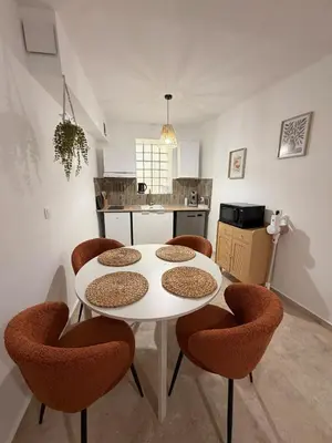 a kitchen with a white table and chairs at Appartement de la flûte in LʼIsle-sur-la-Sorgue