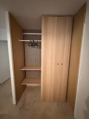 a closet with a wooden cabinet in a room at Appartement de la flûte in LʼIsle-sur-la-Sorgue