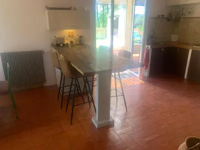 a kitchen with a wooden table and some bar stools at La Bergerie de Saignon in Saignon