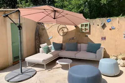 a patio with a couch and an umbrella at La Bergerie de Saignon in Saignon