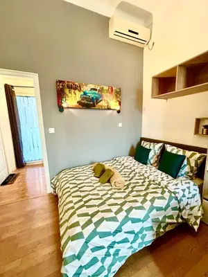 a bedroom with a bed and a painting on the wall at Studio lumineux au cœur du Luberon Parking gratui in Cavaillon