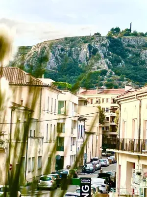a city street with buildings and a mountain in the background at Studio lumineux au cœur du Luberon Parking gratui in Cavaillon