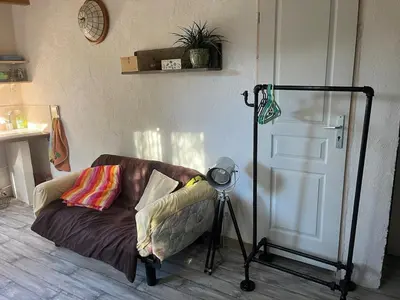 a room with a couch and a camera on a tripod at studio à la campagne avec piscine in Peyrolles-en-Provence