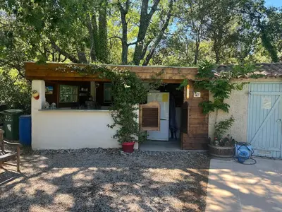a small house with a gate and a garage at studio à la campagne avec piscine in Peyrolles-en-Provence
