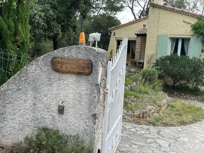 a fence with a wooden door on top of a rock at studio à la campagne avec piscine in Peyrolles-en-Provence