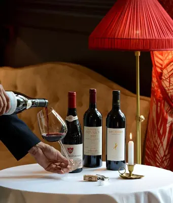 a person pouring a glass of wine on a table at Grand Hôtel Henri - Teritoria in LʼIsle-sur-la-Sorgue