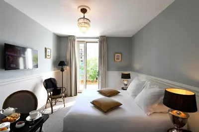 a bedroom with a large white bed and a window at Grand Hôtel Henri - Teritoria in LʼIsle-sur-la-Sorgue