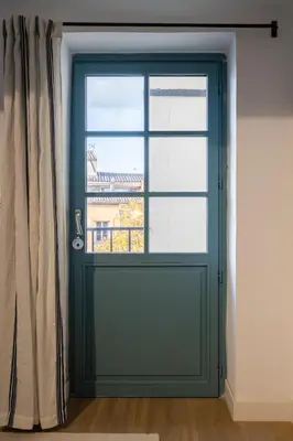 a green door with a window in a room at 2 rooms apartment in the city center in Aix-en-Provence