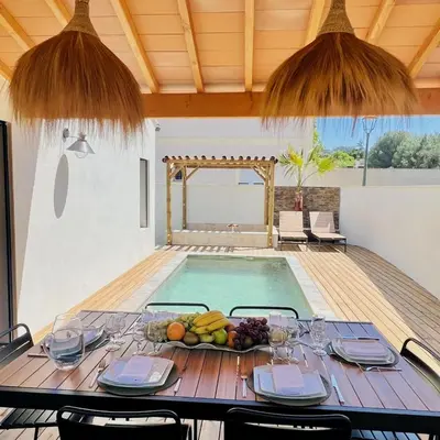 a table with a bowl of fruit next to a swimming pool at Terres de Durance in Charleval