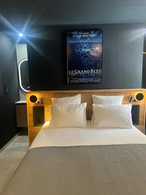 a bedroom with a bed with a poster on the wall at Terres de Durance in Charleval