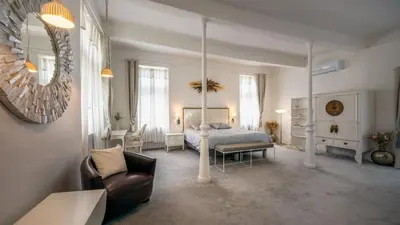 a bedroom with a bed and a chair and a mirror at CHATEAU 18e AVEC PISCINE in La Celle-sous-Gouzon