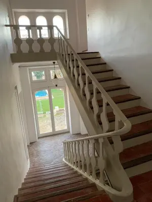 a winding staircase in a house with a window at CHATEAU 18e AVEC PISCINE in La Celle-sous-Gouzon