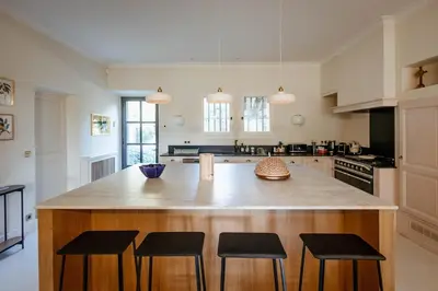 a kitchen with a large island with bar stools at Mas de La Lombarde Saint Rémy de Provence in Saint-Rémy-de-Provence