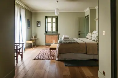 a bedroom with a bed and a table and a window at Mas de La Lombarde Saint Rémy de Provence in Saint-Rémy-de-Provence