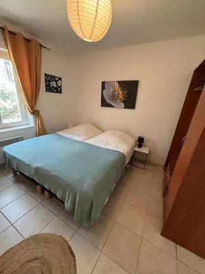 a bedroom with a bed with a blue blanket at Jolie maison avec piscine , proche du centre de Bédoin in Bédoin
